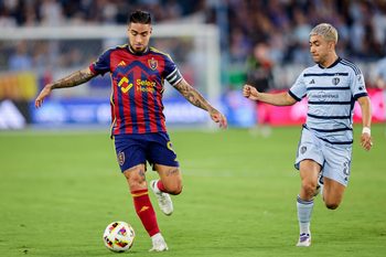 Jun 19, 2024; Kansas City, Kansas, USA; Real Salt Lake forward Cristian Arango (9) brings the ball up field around Sporting Kansas City midfielder Memo Rodríguez (8) during the second half at Children's Mercy Park. Mandatory Credit: William Purnell-Imagn Images