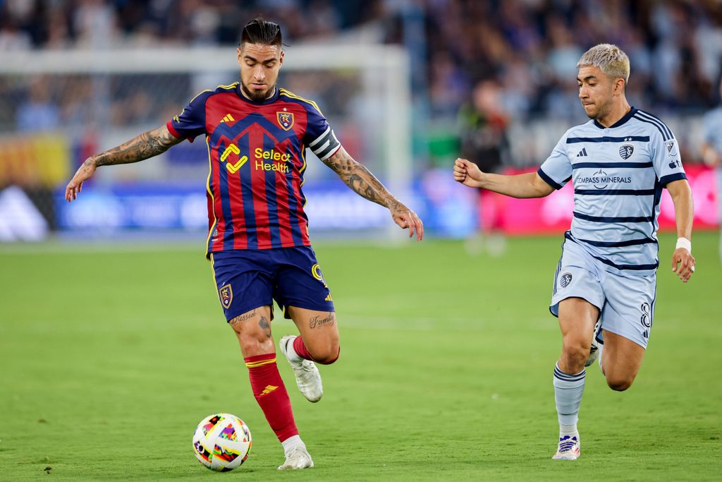 Jun 19, 2024; Kansas City, Kansas, USA; Real Salt Lake forward Cristian Arango (9) brings the ball up field around Sporting Kansas City midfielder Memo Rodríguez (8) during the second half at Children's Mercy Park. Mandatory Credit: William Purnell-Imagn Images