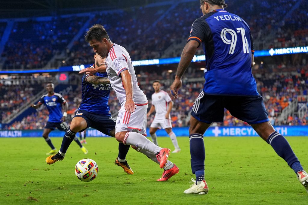Oct 5, 2024; Cincinnati, Ohio, USA; Orlando City SC midfielder Nico Lodeiro (14) dribbles as FC Cincinnati midfielder Luciano Acosta (10) and FC Cincinnati defender DeAndre Yedlin (91) defend during the second half at TQL Stadium. Mandatory Credit: Kareem Elgazzar-Imagn Images