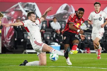 Mar 22, 2025; Harrison, New Jersey, USA; New York Red Bulls forward Serge Ngoma (81) shoots on goal as Toronto FC defender Kevin Long (5) defends during the second half at Sports Illustrated Stadium. Mandatory Credit: Lucas Boland-Imagn Images