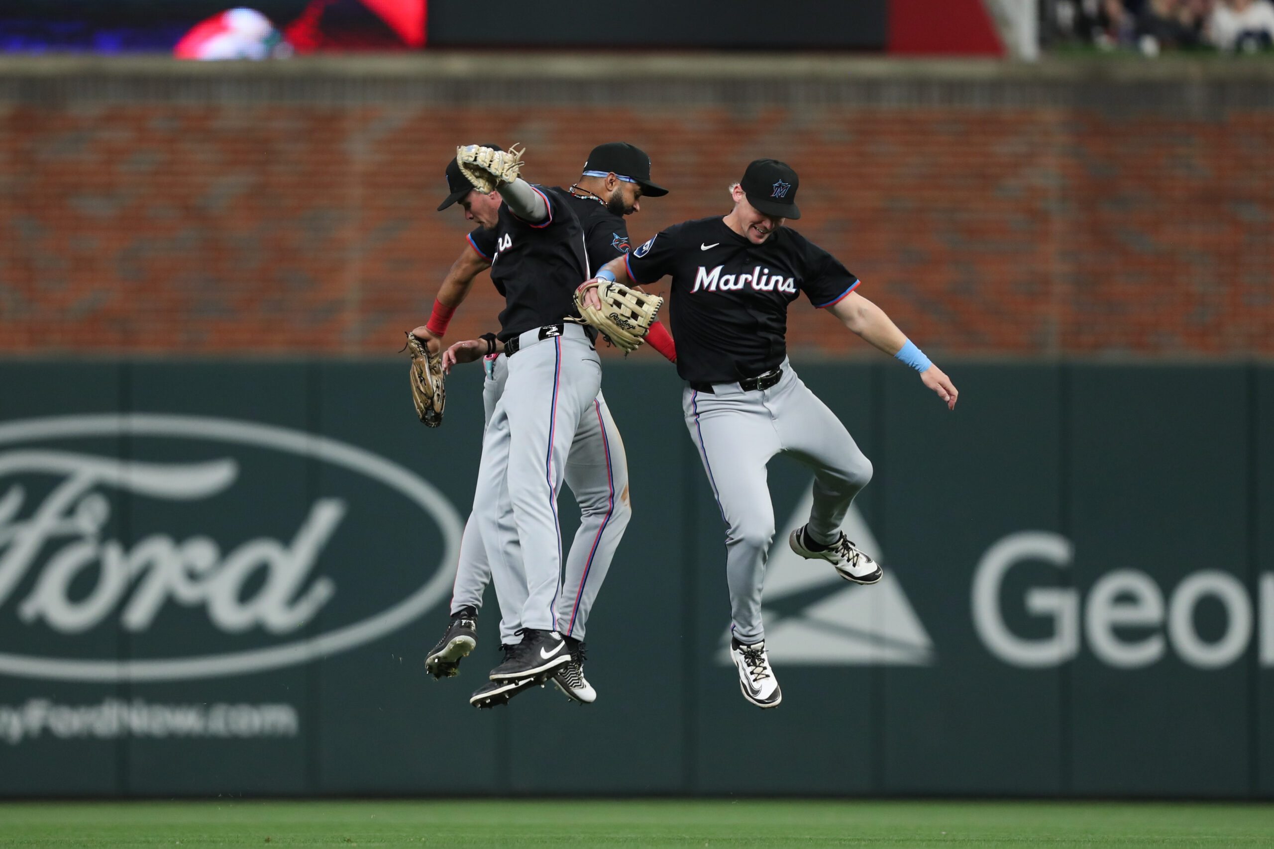 Apr 5, 2025; Cumberland, Georgia, USA; Miami Marlins outfielder Kyle Stowers (28), Miami Marlins outfielder Griffin Conine (18) and Miami Marlins outfielder Derek Hill (3) celebrate the win against the Atlanta Braves at Truist Park. Mandatory Credit: Mady Mertens-Imagn Images