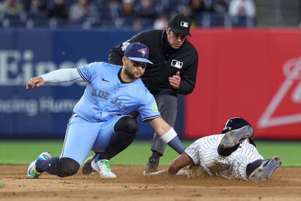 Apr 27, 2025; Bronx, New York, USA; Toronto Blue Jays shortstop Bo Bichette (11) tags out New York Yankees shortstop Anthony Volpe (11) on a steal attempt at second base during the eighth inning at Yankee Stadium. Mandatory Credit: Vincent Carchietta-Imagn Images