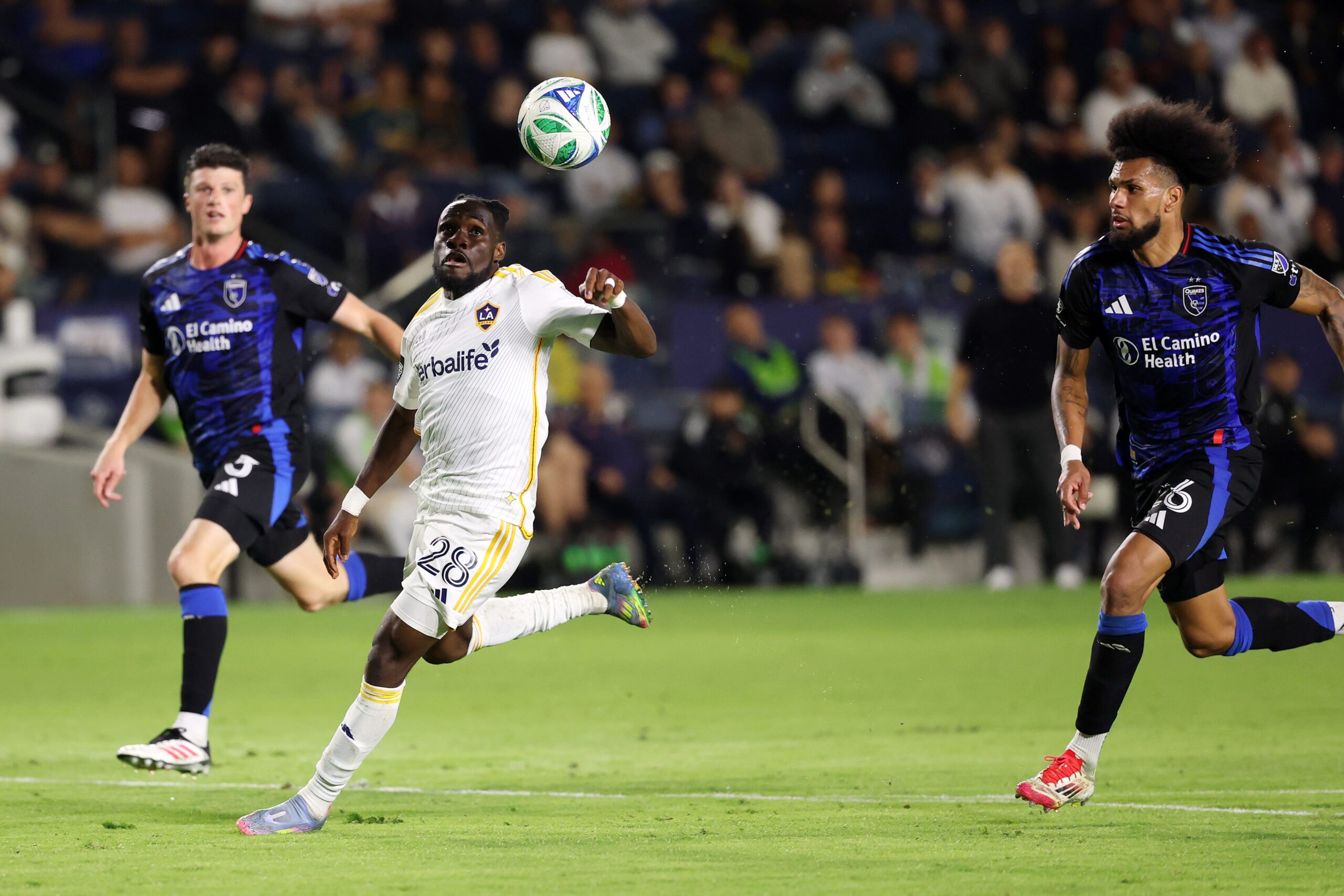 May 28, 2025; Carson, California, USA;  LA Galaxy forward Joseph Paintsil (28) controls the ball between San Jose Earthquakes defender Daniel Munie (5) and defender Rodrigues (26) during the second half at Dignity Health Sports Park. Mandatory Credit: Kiyoshi Mio-Imagn Images