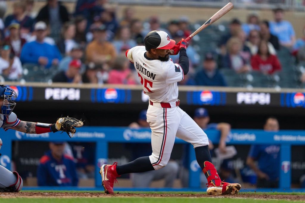 Jun 11, 2025; Minneapolis, Minnesota, USA; Minnesota Twins center fielder Byron Buxton (25) hits a double during the fifth inning against the Texas Rangers at Target Field. Mandatory Credit: Jordan Johnson-Imagn Images