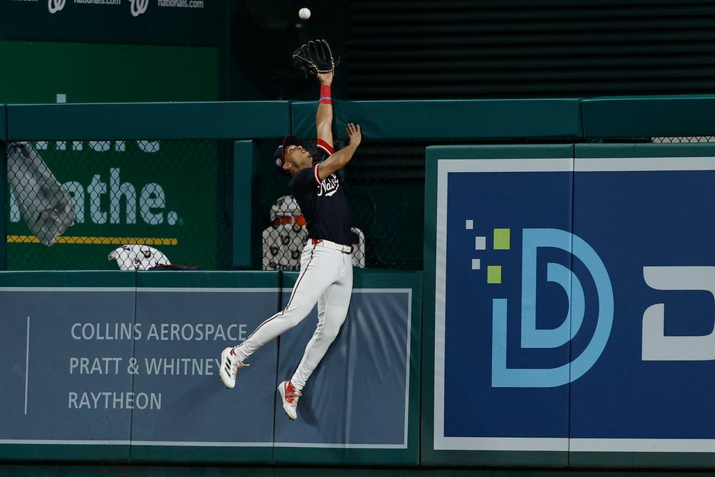 Jun 16, 2025; Washington, District of Columbia, USA; Washington Nationals outfielder Daylen Lile (51) attempts to catch a home run at the fence hit by Colorado Rockies outfielder Mickey Moniak (not pictured) during the ninth inning at Nationals Park. Mandatory Credit: Geoff Burke-Imagn Images