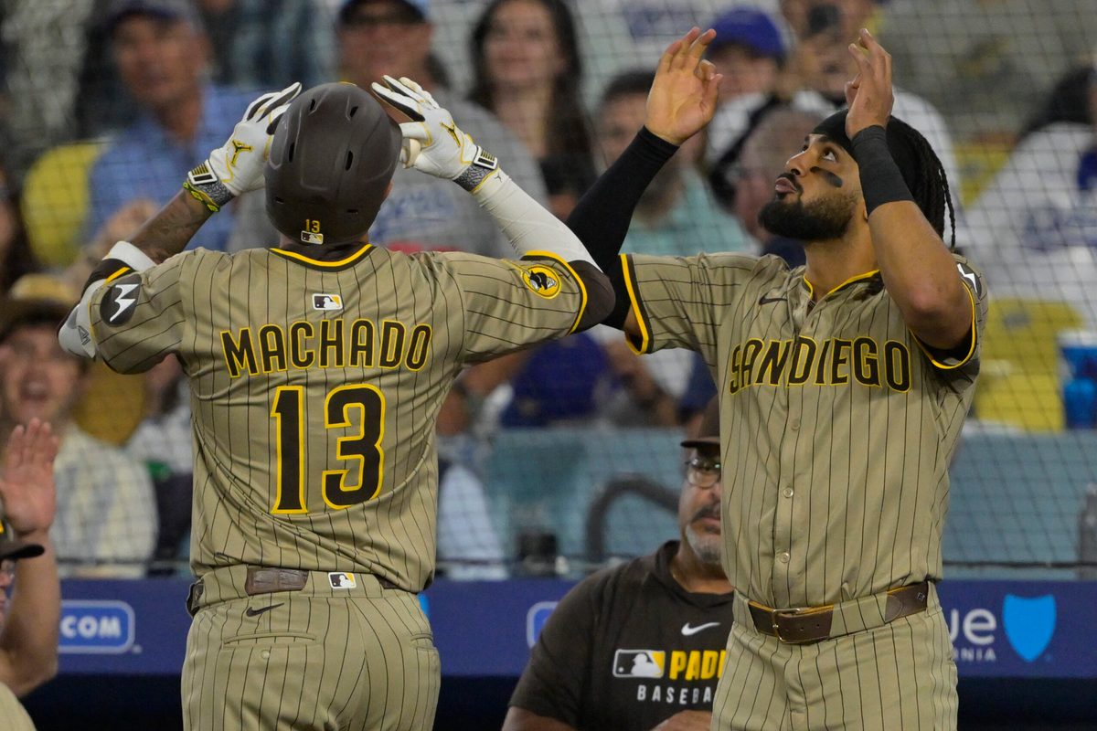 Jun 16, 2025; Los Angeles, California, USA;  San Diego Padres third baseman Manny Machado (13) celebrates with right fielder Fernando Tatis Jr. (23) after a solo home run in the sixth inning against the Los Angeles Dodgers at Dodger Stadium. Mandatory Credit: Jayne Kamin-Oncea-Imagn Images