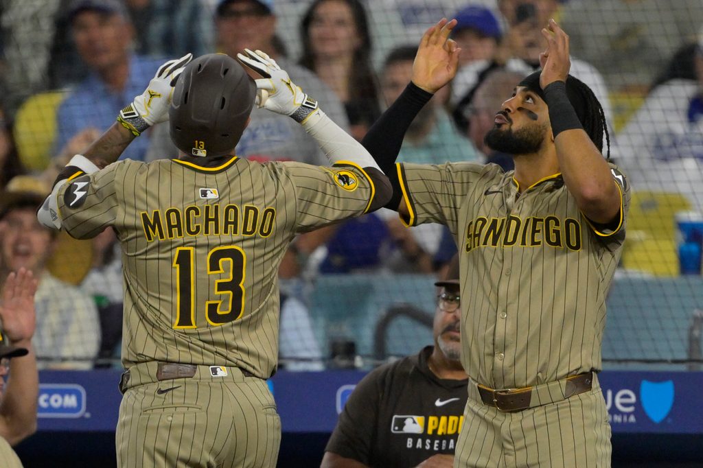Jun 16, 2025; Los Angeles, California, USA; San Diego Padres third baseman Manny Machado (13) celebrates with right fielder Fernando Tatis Jr. (23) after a solo home run in the sixth inning against the Los Angeles Dodgers at Dodger Stadium. Mandatory Credit: Jayne Kamin-Oncea-Imagn Images