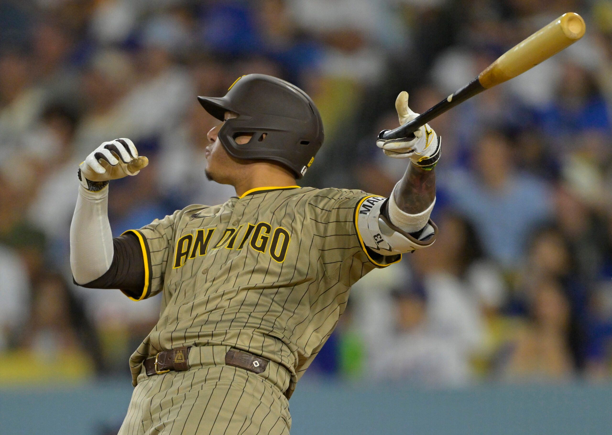 Jun 16, 2025; Los Angeles, California, USA;  San Diego Padres third baseman Manny Machado (13) flips his bat after hitting a solo home run in the sixth inning against the Los Angeles Dodgers at Dodger Stadium. Mandatory Credit: Jayne Kamin-Oncea-Imagn Images