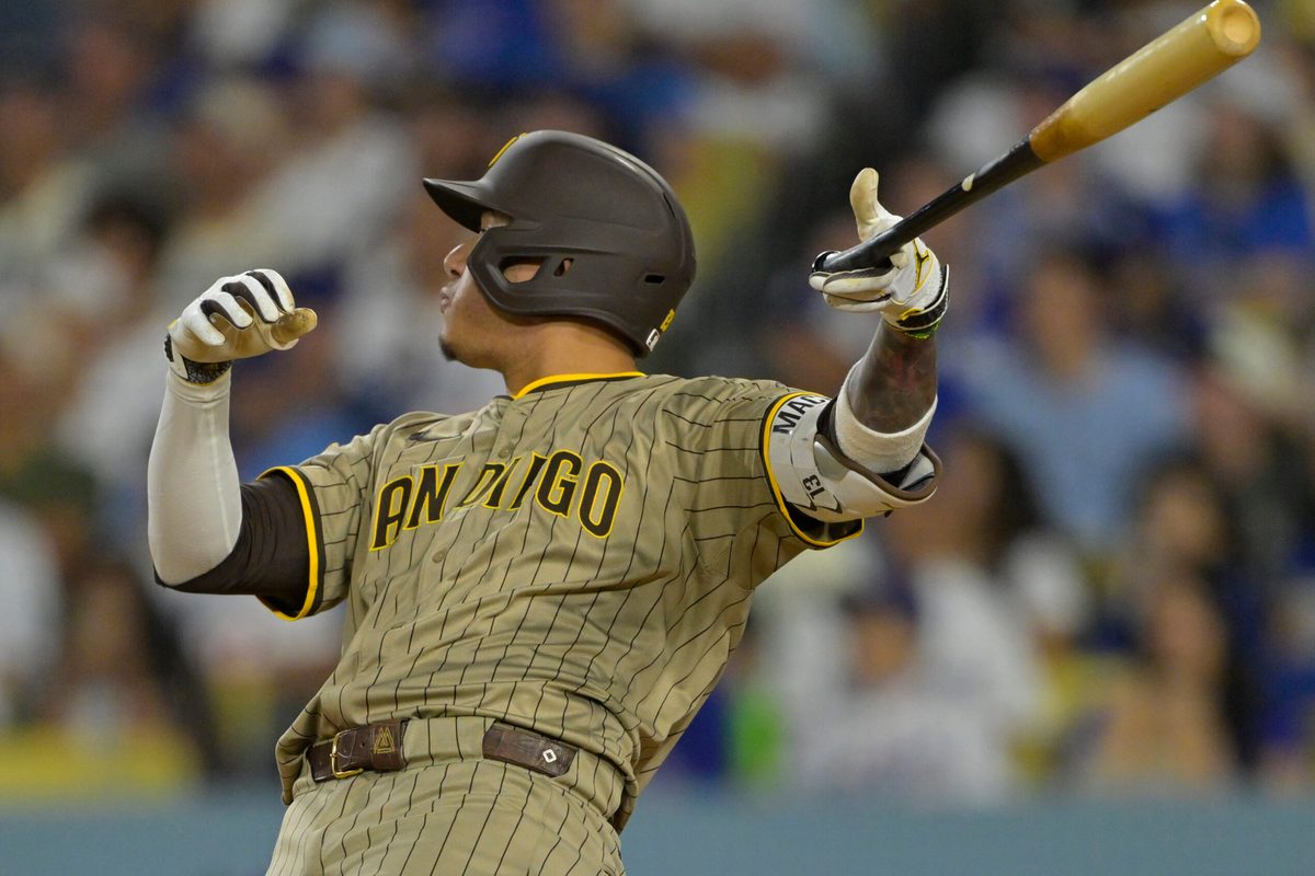 Jun 16, 2025; Los Angeles, California, USA;  San Diego Padres third baseman Manny Machado (13) flips his bat after hitting a solo home run in the sixth inning against the Los Angeles Dodgers at Dodger Stadium. Mandatory Credit: Jayne Kamin-Oncea-Imagn Images