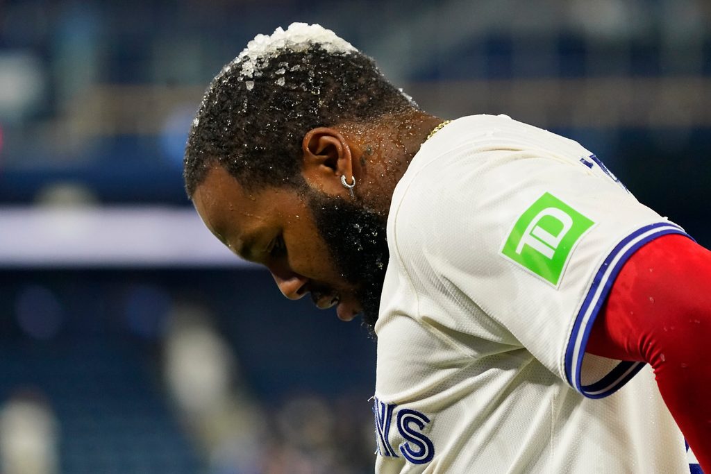 Jun 18, 2025; Toronto, Ontario, CAN; Ice sits on top of Toronto Blue Jays first baseman Vladimir Guerrero (27) after being doused with Gatorade after a win over the Arizona Diamondbacks at Rogers Centre. Mandatory Credit: John E. Sokolowski-Imagn Images