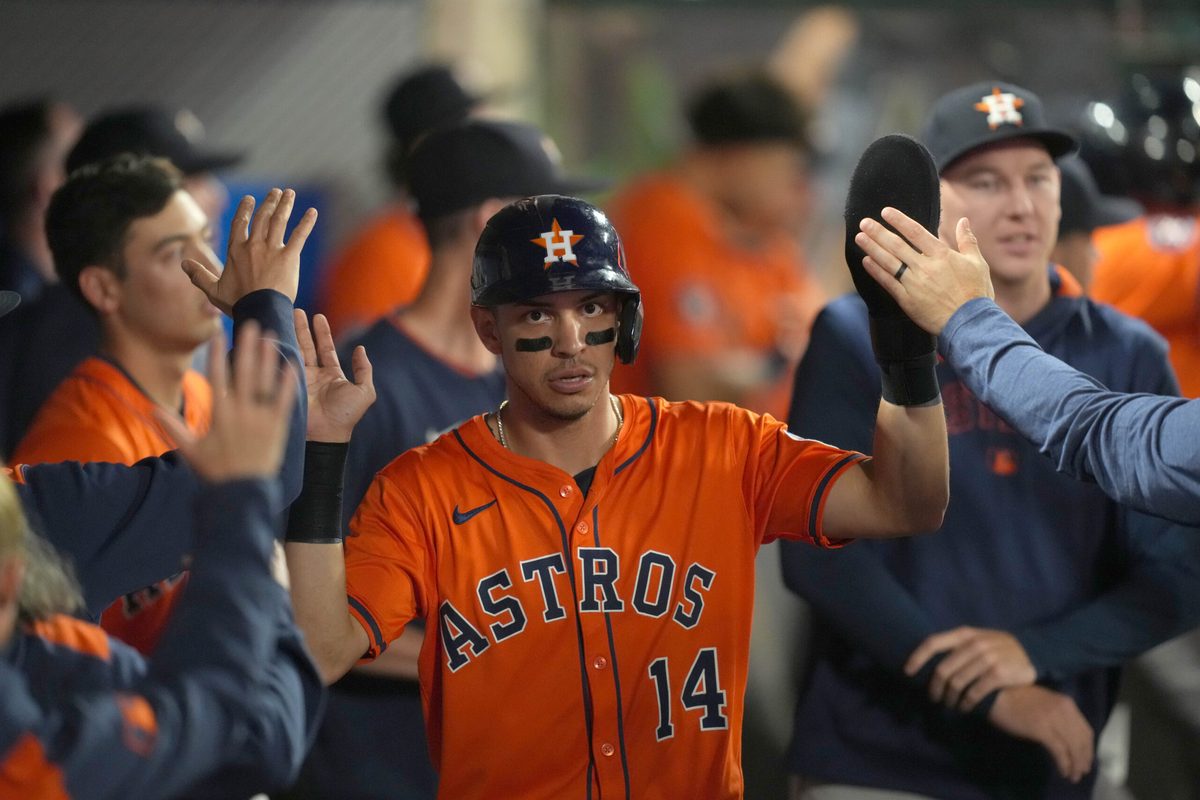 Jun 20, 2025; Anaheim, California, USA; Houston Astros second baseman Mauricio Dubon (14) is congratulated by teammates after scoring in the 10th inning against the Los Angeles Angels at Angel Stadium. Mandatory Credit: Kirby Lee-Imagn Images