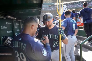 Jun 21, 2025; Chicago, Illinois, USA; Seattle Mariners catcher Cal Raleigh (29) is greeted in the dugout after hitting a home run against the Chicago Cubs during the ninth inning at Wrigley Field. Mandatory Credit: David Banks-Imagn Images