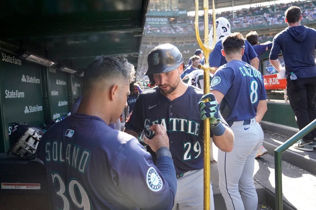 Jun 21, 2025; Chicago, Illinois, USA; Seattle Mariners catcher Cal Raleigh (29) is greeted in the dugout after hitting a home run against the Chicago Cubs during the ninth inning at Wrigley Field. Mandatory Credit: David Banks-Imagn Images