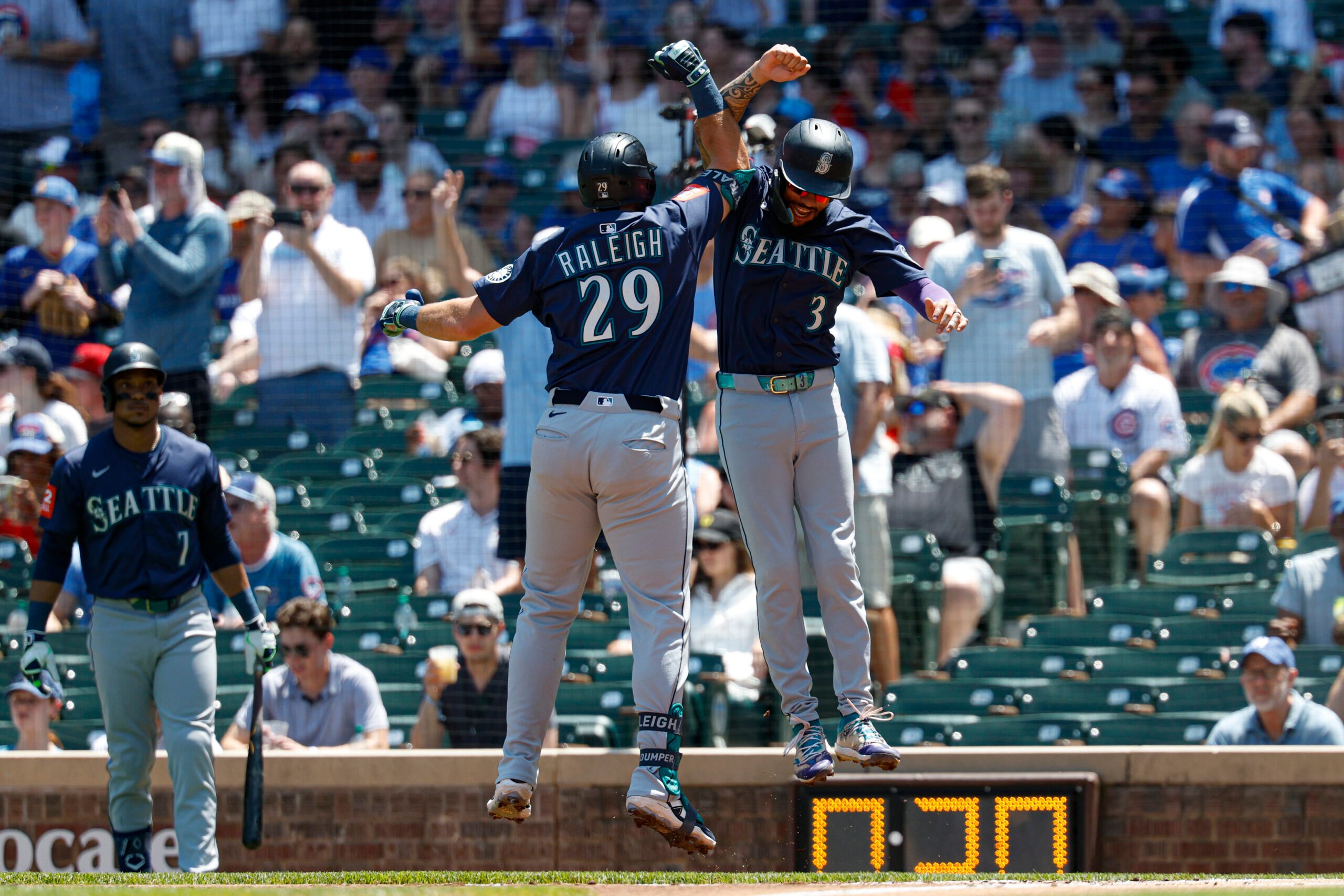 Jun 22, 2025; Chicago, Illinois, USA; Seattle Mariners designated hitter Cal Raleigh (29) celebrates with shortstop J.P. Crawford (3) after hitting a two-run home run against the Chicago Cubs during the first inning at Wrigley Field. Mandatory Credit: Kamil Krzaczynski-Imagn Images