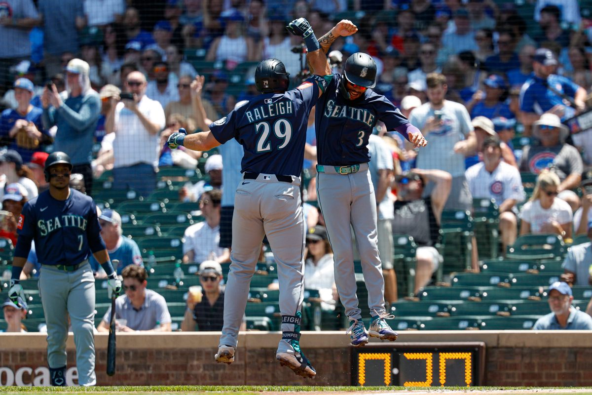 Jun 22, 2025; Chicago, Illinois, USA; Seattle Mariners designated hitter Cal Raleigh (29) celebrates with shortstop J.P. Crawford (3) after hitting a two-run home run against the Chicago Cubs during the first inning at Wrigley Field. Mandatory Credit: Kamil Krzaczynski-Imagn Images
