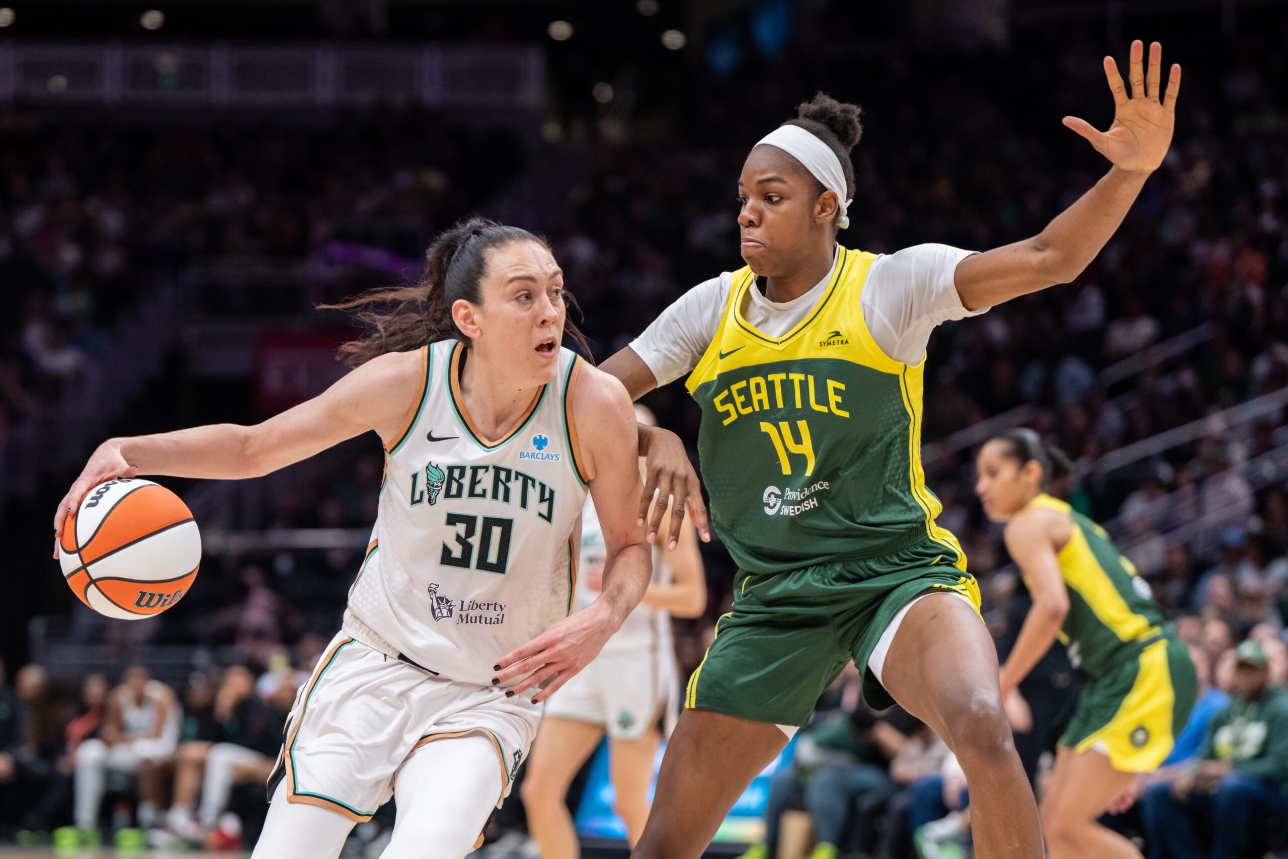 Jun 22, 2025; Seattle, Washington, USA;  New York Libertyforward Breanna Stewart (30) dribbles the ball against Seattle Storm center Dominique Malonga (14) during the second half at Climate Pledge Arena. Mandatory Credit: Stephen Brashear-Imagn Images