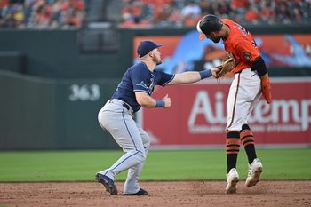 Jun 28, 2025; Baltimore, Maryland, USA; Tampa Bay Rays first baseman Curtis Mead (25) tags out Baltimore Orioles left fielder Colton Cowser (17) at second base during the ninth inning at Oriole Park at Camden Yards. Mandatory Credit: Rafael Suanes-Imagn Images