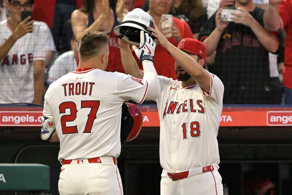 Jun 28, 2025; Anaheim, California, USA; Los Angeles Angels right fielder Mike Trout (27) is is greeted at the dugout by first baseman Nolan Schanuel (18) after hitting a solo home run in the seventh inning against the Washington Nationals at Angel Stadium. Mandatory Credit: Jayne Kamin-Oncea-Imagn Images