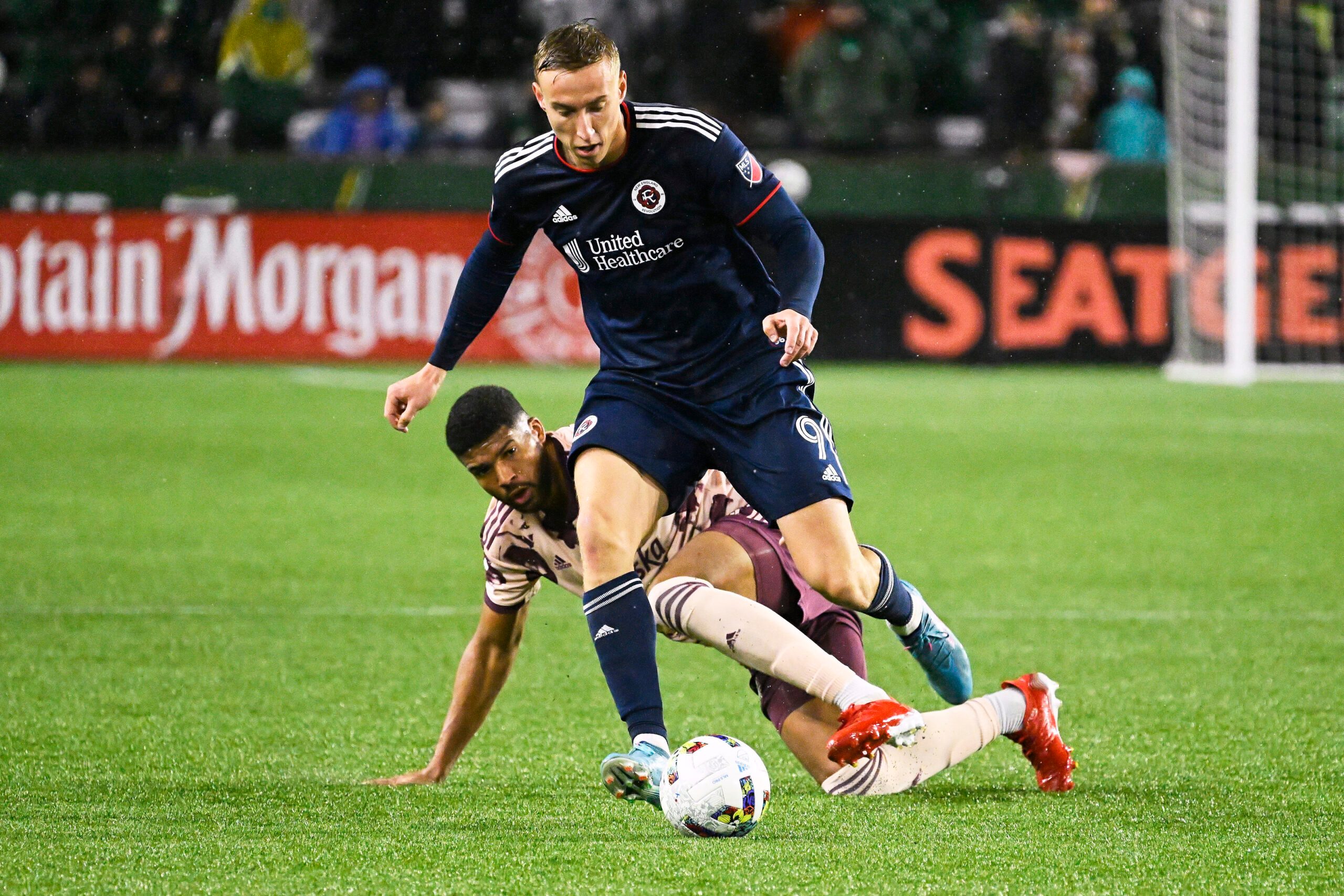 Feb 26, 2022; Portland, Oregon, USA; Portland Timbers defender Zac McGraw (18) defends New England Revolution forward Adam Buksa (9) during the second half at Providence Park. The game ended in a tie 2-2. Mandatory Credit: Troy Wayrynen-Imagn Images