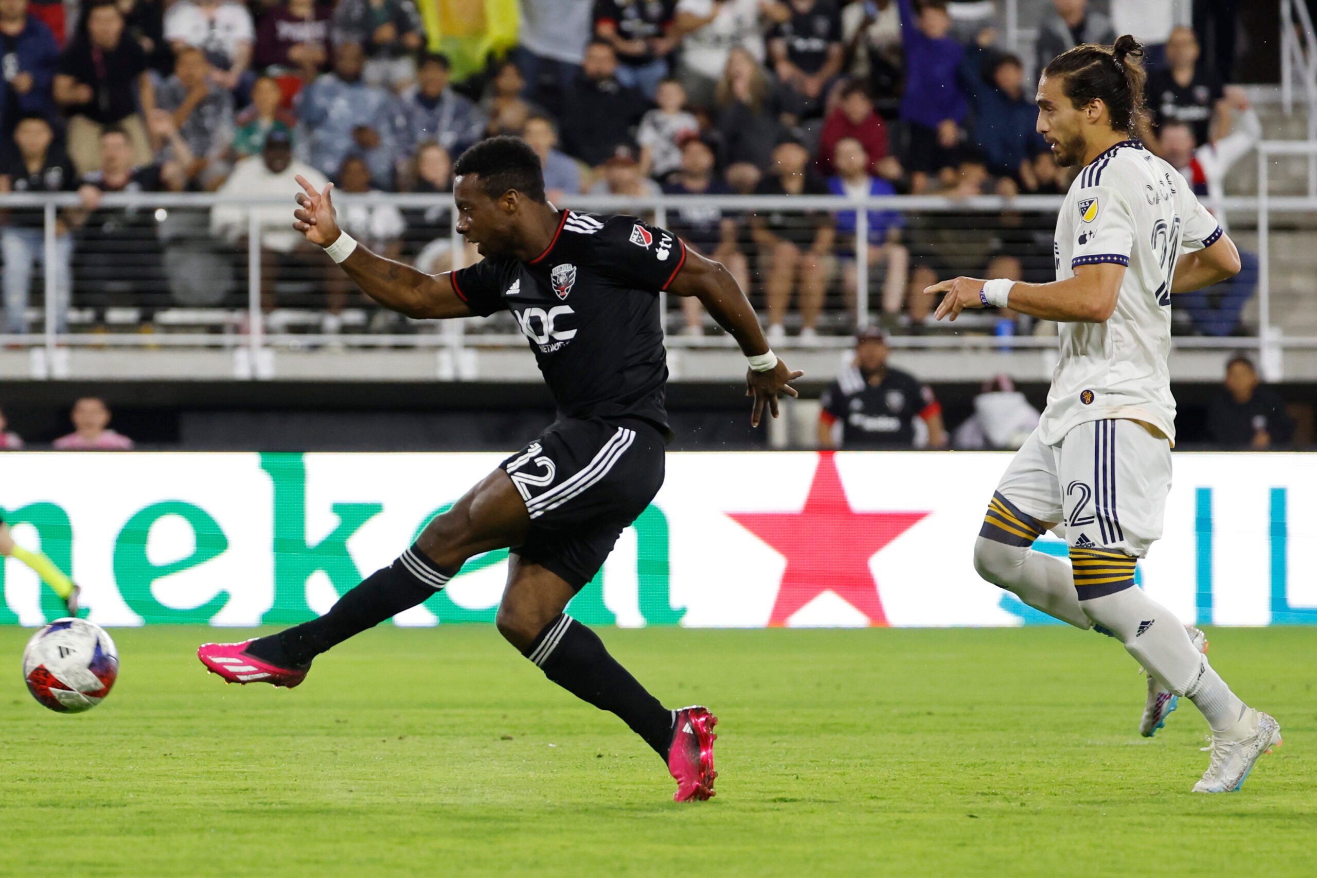 May 20, 2023; Washington, District of Columbia, USA; D.C. United forward Cristi n D jome (12)  scores a goal as LA Galaxy defender Mart n C ceres (22) looks on in the second half at Audi Field. Mandatory Credit: Geoff Burke-Imagn Images