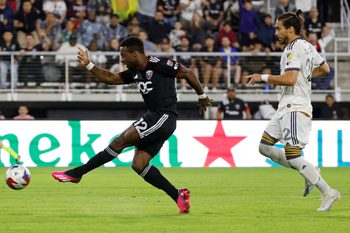 May 20, 2023; Washington, District of Columbia, USA; D.C. United forward Cristi n D jome (12)  scores a goal as LA Galaxy defender Mart n C ceres (22) looks on in the second half at Audi Field. Mandatory Credit: Geoff Burke-Imagn Images