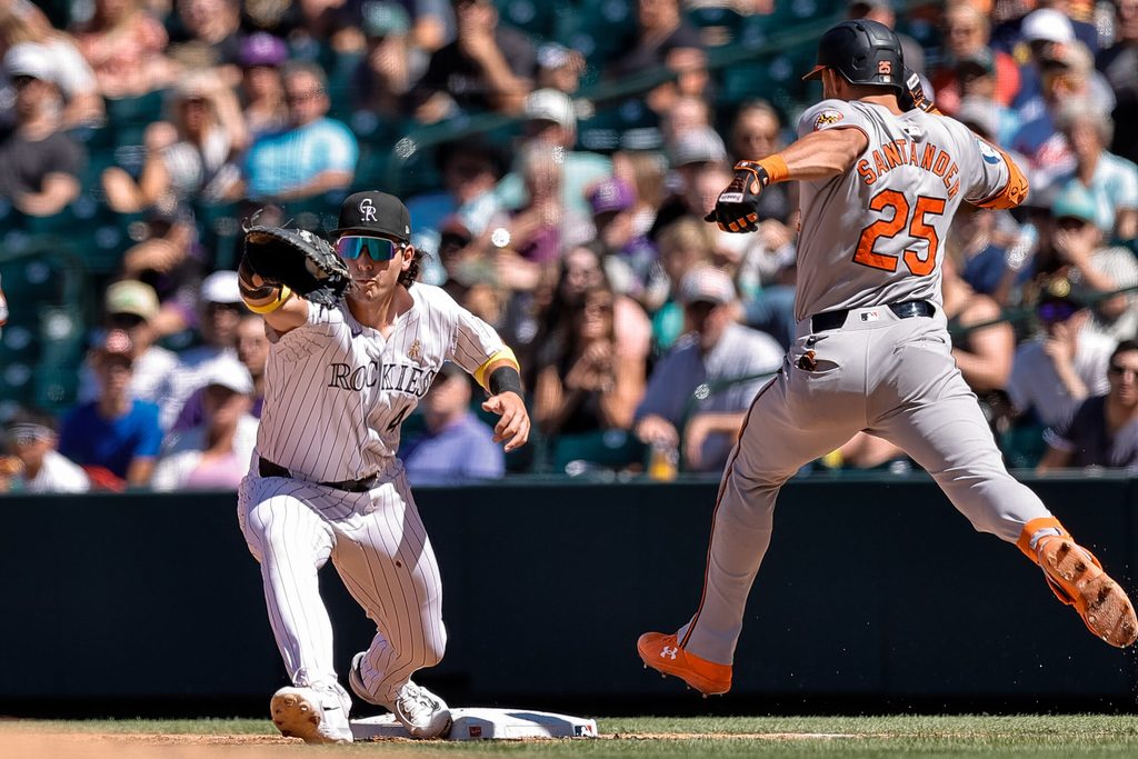 Sep 1, 2024; Denver, Colorado, USA; Baltimore Orioles right fielder Anthony Santander (25) is thrown out at first against Colorado Rockies first baseman Michael Toglia (4) in the fifth inning at Coors Field. Mandatory Credit: Isaiah J. Downing-Imagn Images
