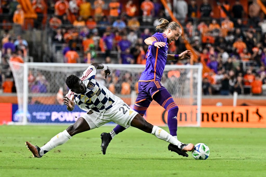 Mar 15, 2025; Houston, Texas, USA; Real Salt Lake forward Forster Ajago (27) steals the ball from Houston Dynamo midfielder Griffin Dorsey (25) during the second half at Shell Energy Stadium. Mandatory Credit: Maria Lysaker-Imagn Images