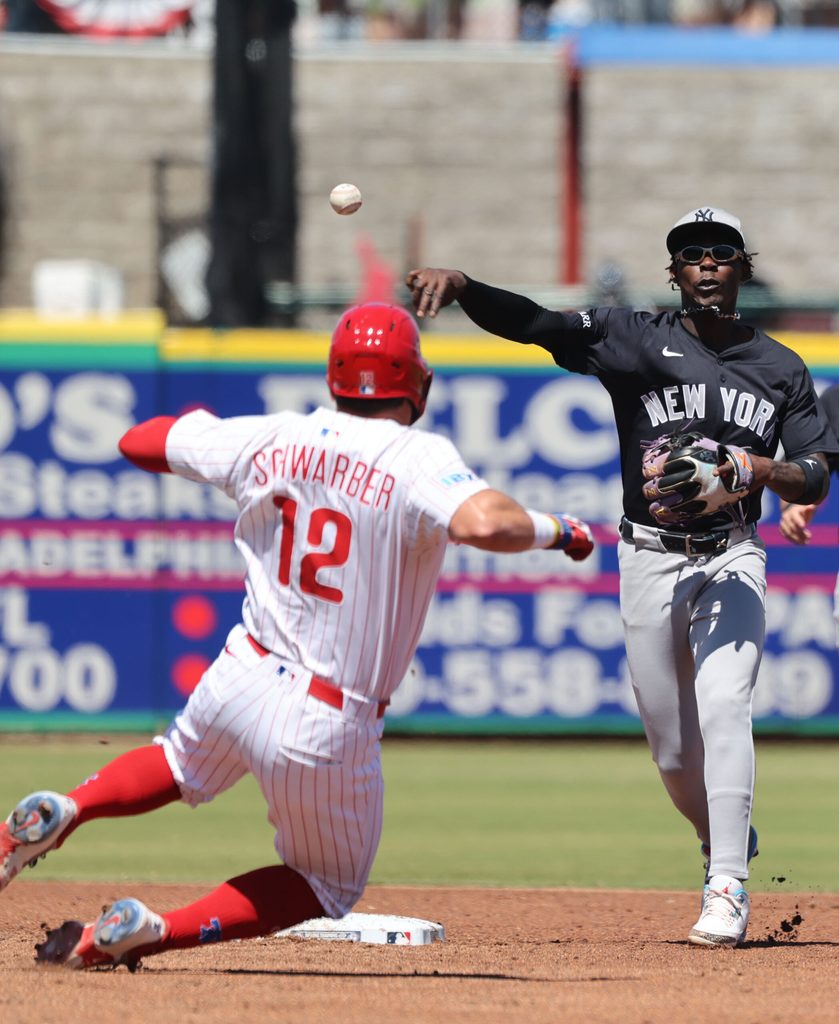 Mar 19, 2025; Clearwater, Florida, USA;  New York Yankees third base Jazz Chisholm Jr. (13) forces out Philadelphia Phillies designated hitter Kyle Schwarber (12) and throws the ball to first base for a double play during the third inning at BayCare Ballpark. Mandatory Credit: Kim Klement Neitzel-Imagn Images