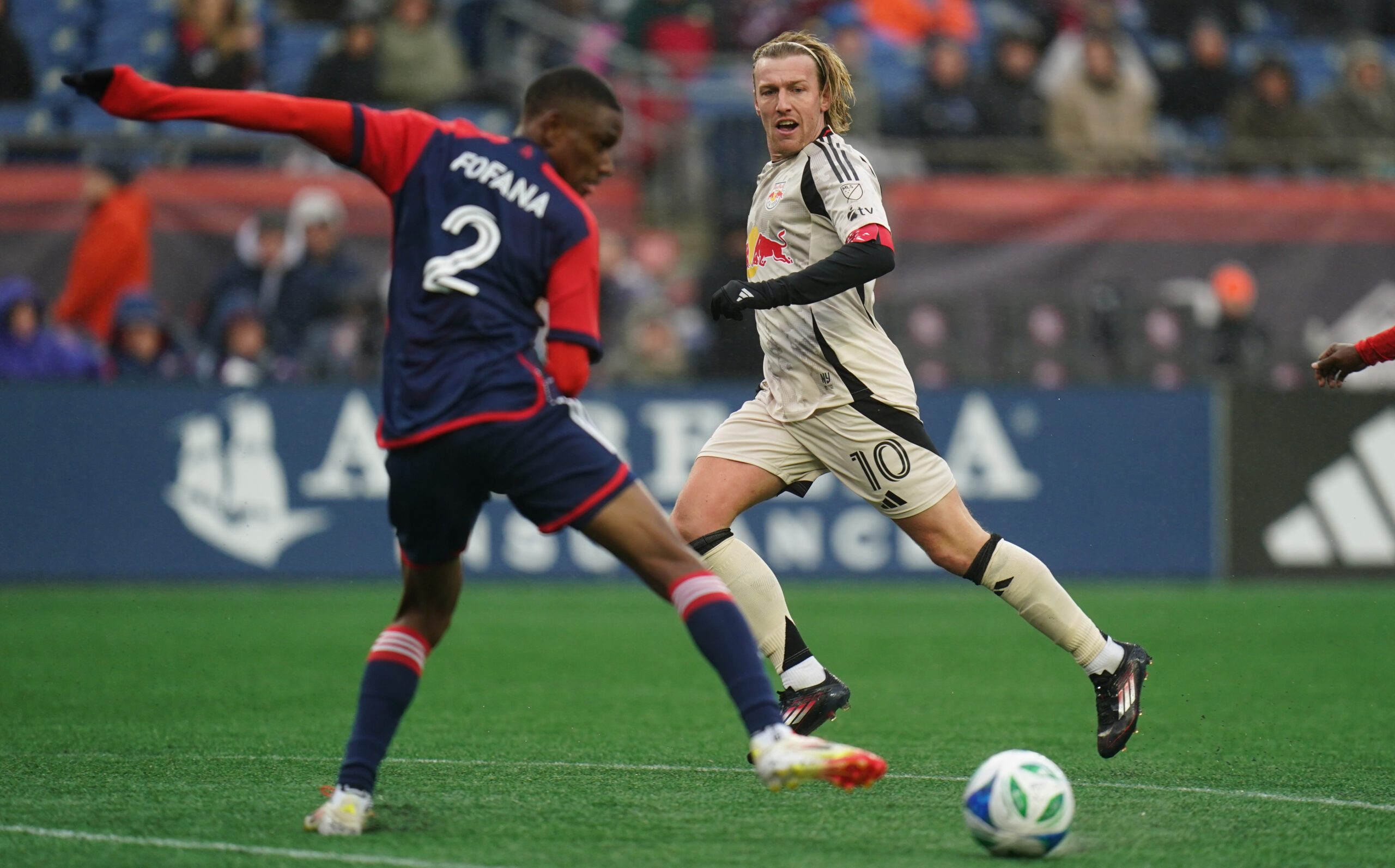 Mar 29, 2025; Foxborough, Massachusetts, USA; New York Red Bulls midfielder Emil Forsberg (10) passes the ball against New England Revolution defender Mamadou Fofana (2) in the second half at Gillette Stadium. Mandatory Credit: David Butler II-Imagn Images
