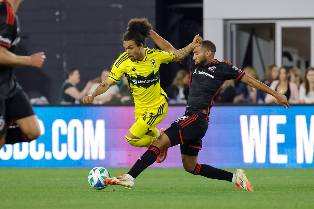Mar 29, 2025; Washington, District of Columbia, USA; Columbus Crew midfielder Aziel Jackson (13) and D.C. United defender Derek Dodson (18) battle for the ball during the second half at Audi Field. Mandatory Credit: Amber Searls-Imagn Images
