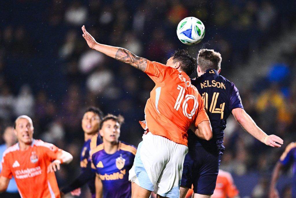 Apr 12, 2025; Carson, California, USA; Houston Dynamo FC goalkeeper Jimmy Maurer (1) and LA Galaxy defender John Nelson (14) battle for the header during the second half at Dignity Health Sports Park. Mandatory Credit: Kelvin Kuo-Imagn Images