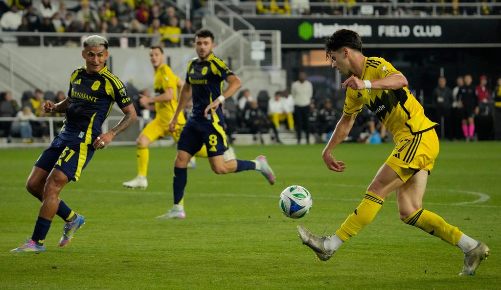 Columbus Crew forward Max Arfsten (27) crosses the ball against Nashville SC midfielder Andy Najar (31) in the second half during their MLS game at Lower.com Field on May 28, 2025.