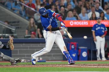 Jun 30, 2025; Toronto, Ontario, CAN; Toronto Blue Jays first baseman Vladimir Guerrero Jr. (27) hits a two-run double against the New York Yankees during the sixth inning at Rogers Centre. Mandatory Credit: Nick Turchiaro-Imagn Images
