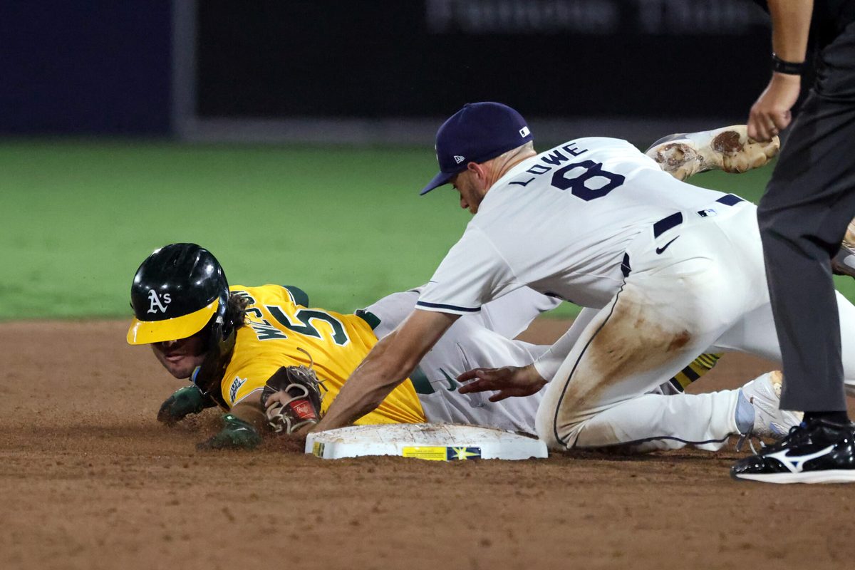 Jun 30, 2025; Tampa, Florida, USA; Tampa Bay Rays second base Brandon Lowe (8) tags out Athletics shortstop Jacob Wilson (5) during the ninth inning at George M. Steinbrenner Field. Mandatory Credit: Kim Klement Neitzel-Imagn Images