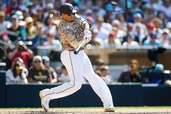 Jul 4, 2025; San Diego, California, USA; San Diego Padres third baseman Manny Machado (13) hits a one run home run during the fourth inning against the Texas Rangers at Petco Park. Mandatory Credit: David Frerker-Imagn Images