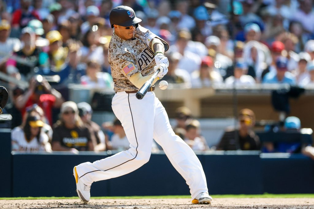 Jul 4, 2025; San Diego, California, USA; San Diego Padres third baseman Manny Machado (13) hits a one run home run during the fourth inning against the Texas Rangers at Petco Park. Mandatory Credit: David Frerker-Imagn Images