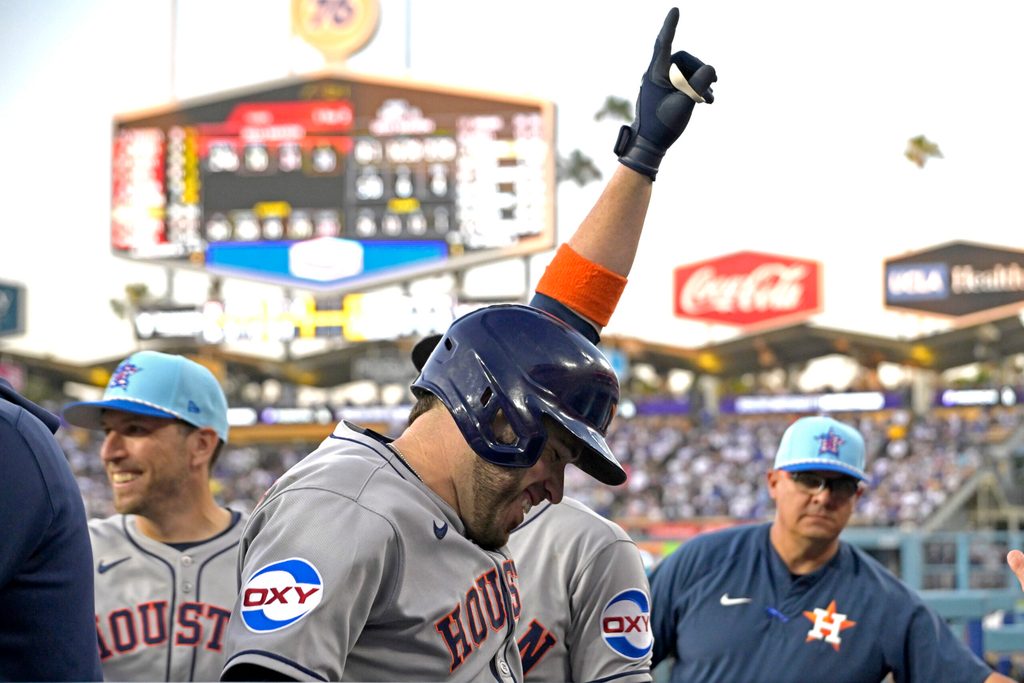 Jul 4, 2025; Los Angeles, California, USA; Houston Astros catcher Victor Caratini (17) celebrates as he enters the dugout after hitting a grand slam home run in the sixth inning against the Los Angeles Dodgers at Dodger Stadium. Mandatory Credit: Jayne Kamin-Oncea-Imagn Images