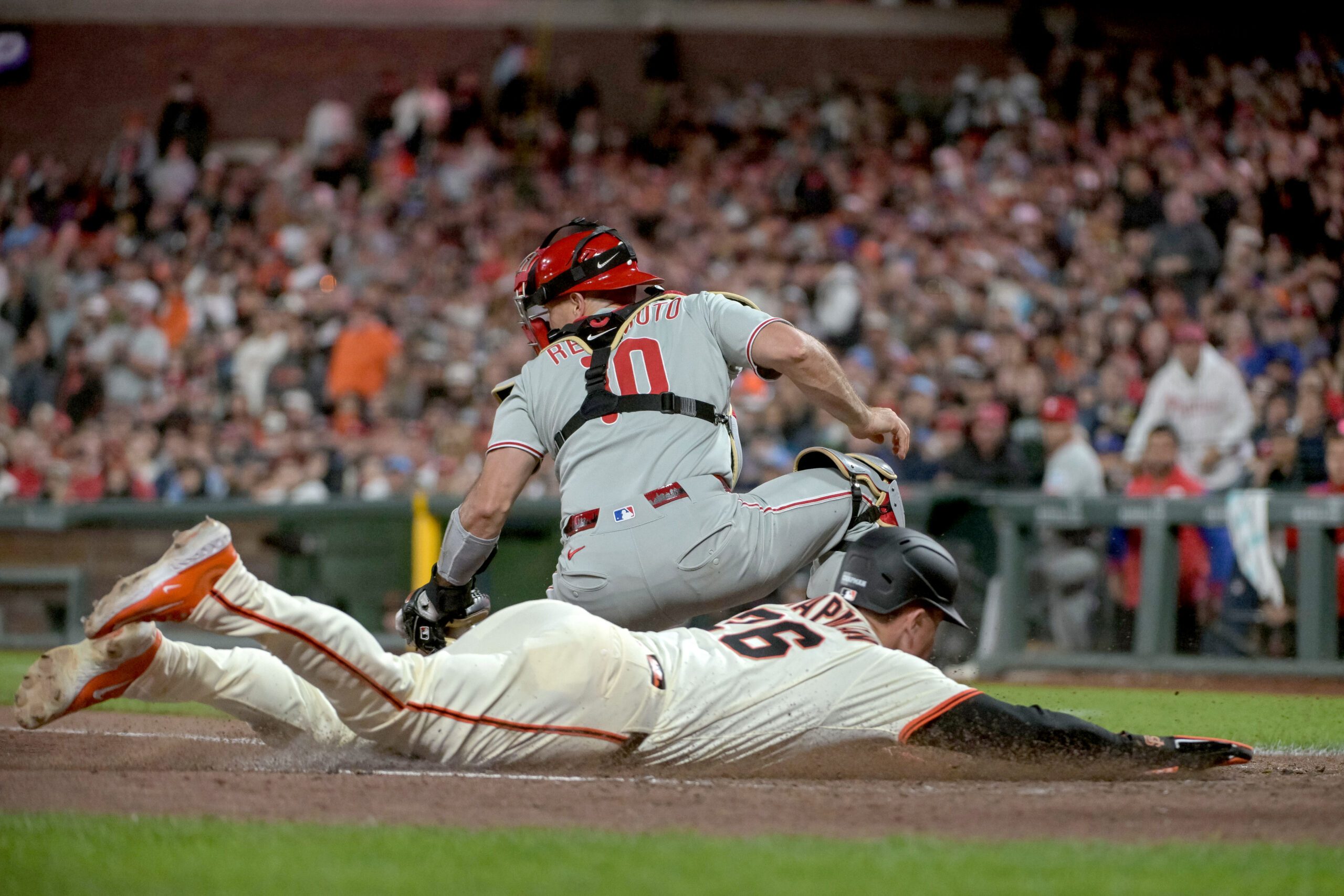 Jul 7, 2025; San Francisco, California, USA; San Francisco Giants third baseman Matt Chapman (26) slides safe into home plate against the Philadelphia Phillies during the eighth inning at Oracle Park. Mandatory Credit: Ed Szczepanski-Imagn Images