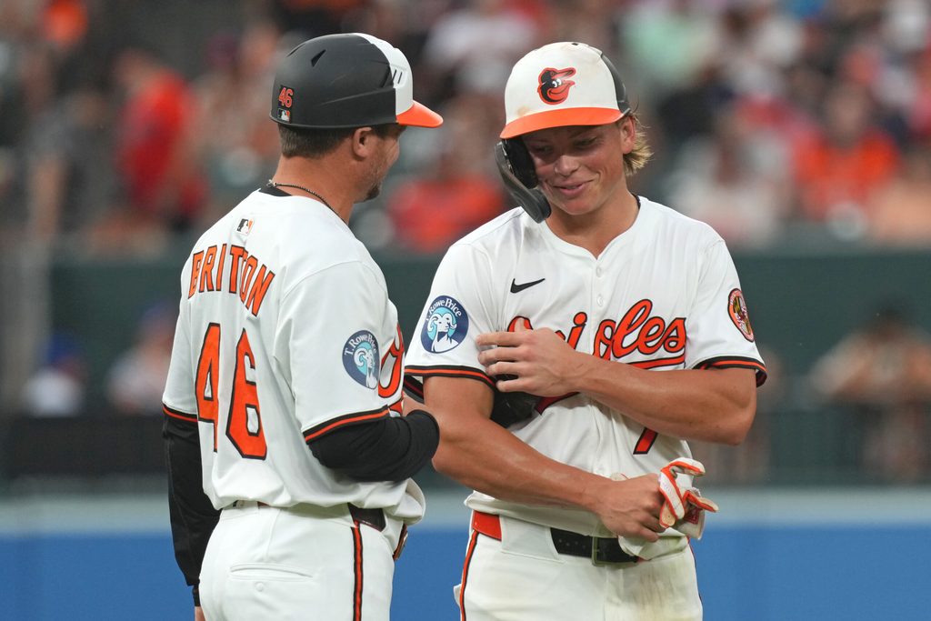 Jul 8, 2025; Baltimore, Maryland, USA; Baltimore Orioles second baseman Jackson Holliday (7) shares a moment with third base coach Buck Britton (46) at the end of the third inning against the New York Mets at Oriole Park at Camden Yards. Mandatory Credit: Mitch Stringer-Imagn Images