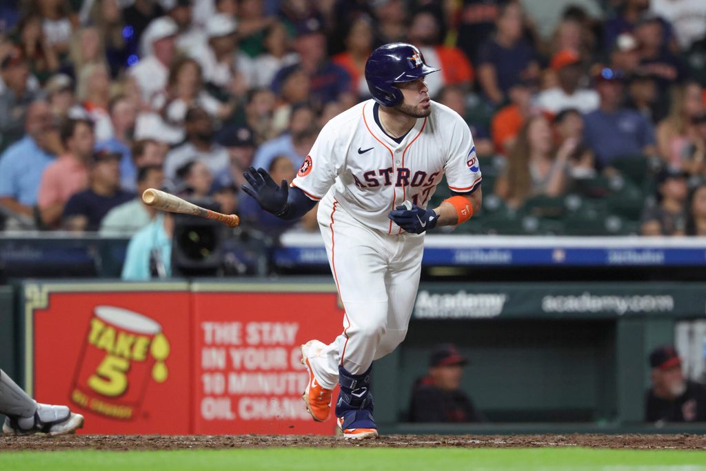 Jul 8, 2025; Houston, Texas, USA; Houston Astros first baseman Victor Caratini (17) drives in a run with a sacrifice fly during the fifth inning against the Cleveland Guardians at Daikin Park. Mandatory Credit: Troy Taormina-Imagn Images