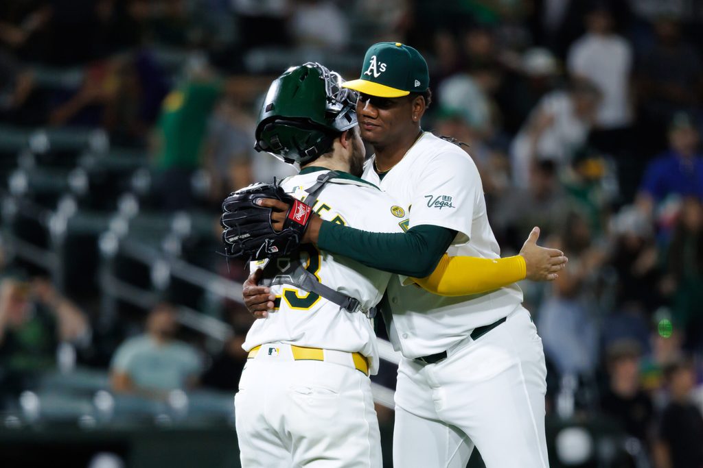 Jul 8, 2025; West Sacramento, California, USA; Athletics pitcher Elvis Alvarado (61) and catcher Shea Langeliers (23) hug after the game against the Atlanta Braves at Sutter Health Park. Mandatory Credit: Sergio Estrada-Imagn Images