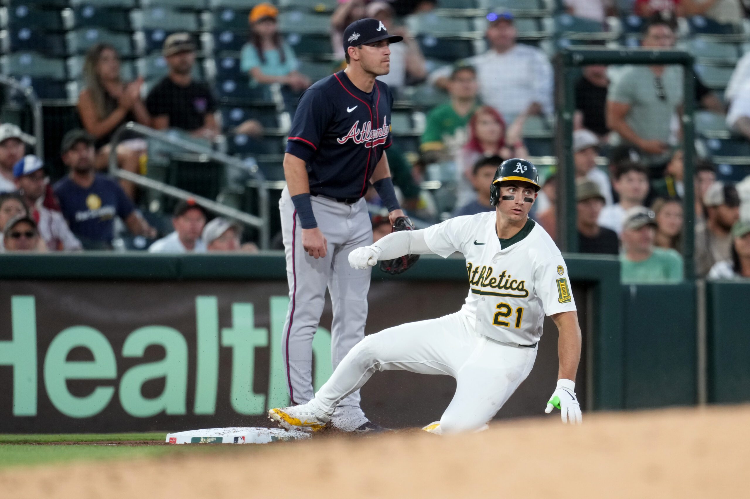 Jul 9, 2025; West Sacramento, California, USA; Athletics left fielder Tyler Soderstrom (21) advances to third base in front of Atlanta Braves third baseman Austin Riley (27) in the sixth inning at Sutter Health Park. Mandatory Credit: Cary Edmondson-Imagn Images