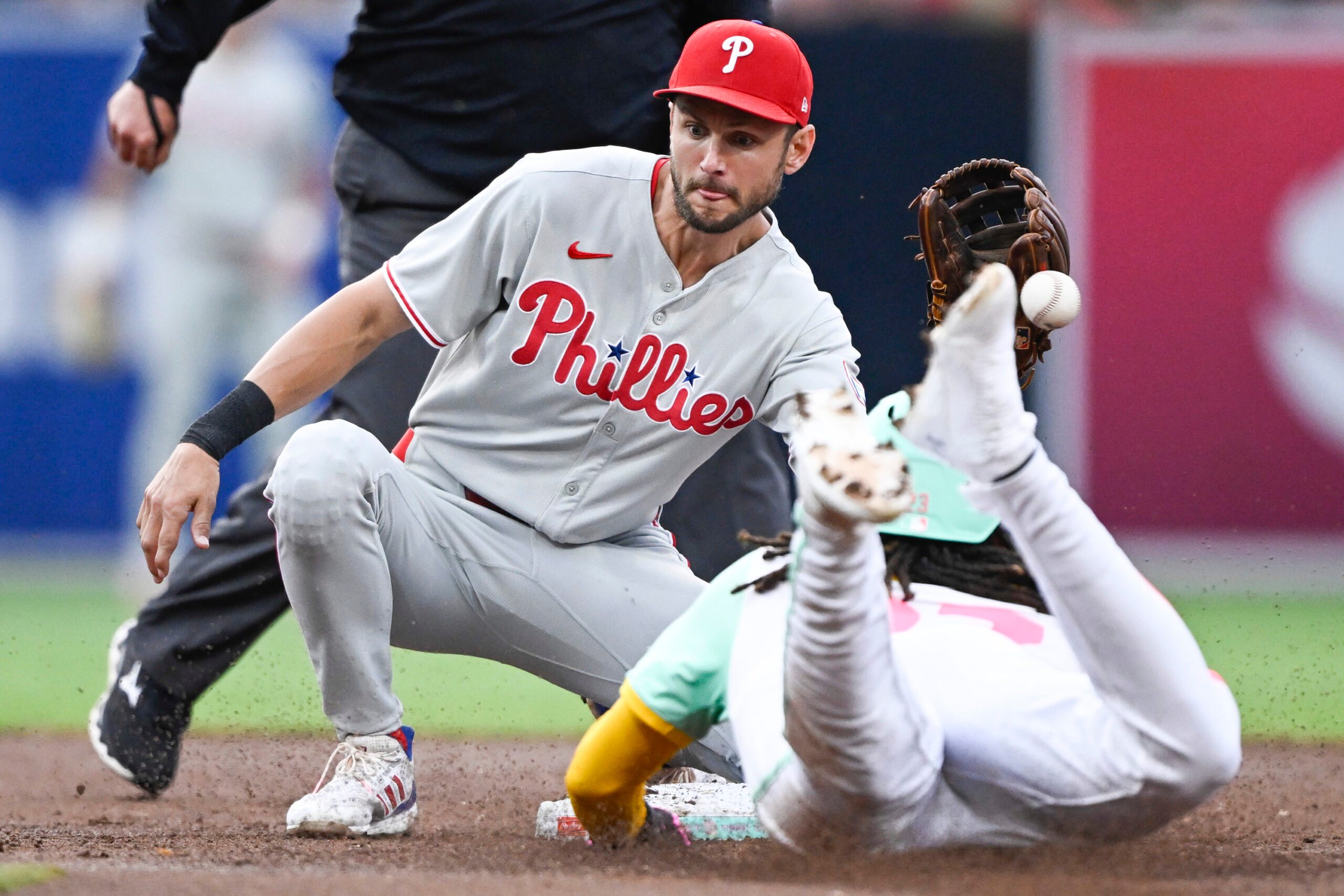 Jul 11, 2025; San Diego, California, USA; San Diego Padres right fielder Fernando Tatis Jr. (23) steals second base as Philadelphia Phillies shortstop Trea Turner (7) loses the ball during the third inning at Petco Park. Mandatory Credit: Denis Poroy-Imagn Images