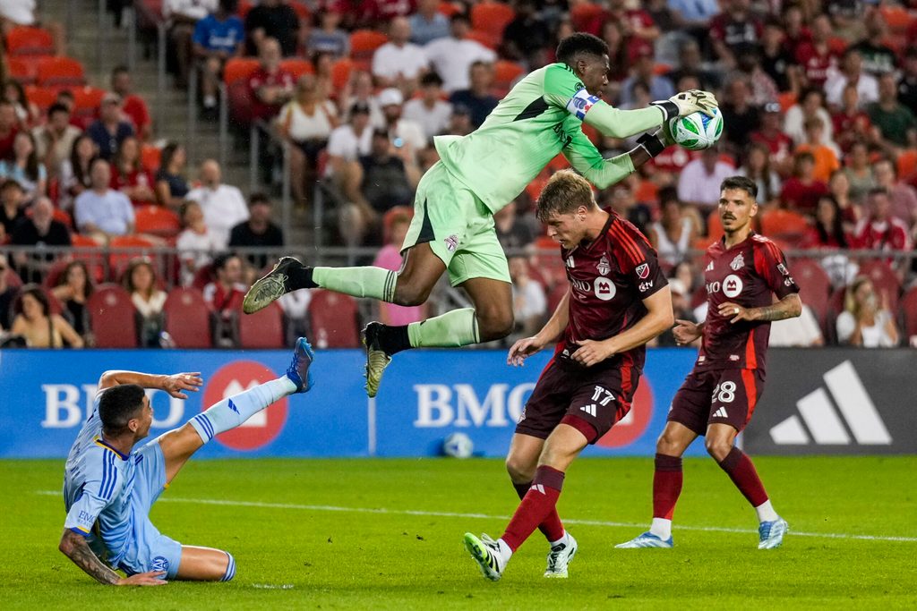 Jul 12, 2025; Toronto, Ontario, CAN; Toronto FC goalkeeper Sean Johnson (1) makes a save against Atlanta United midfielder Miguel Almirón (10) during the second half at BMO Field. Mandatory Credit: Kevin Sousa-Imagn Images