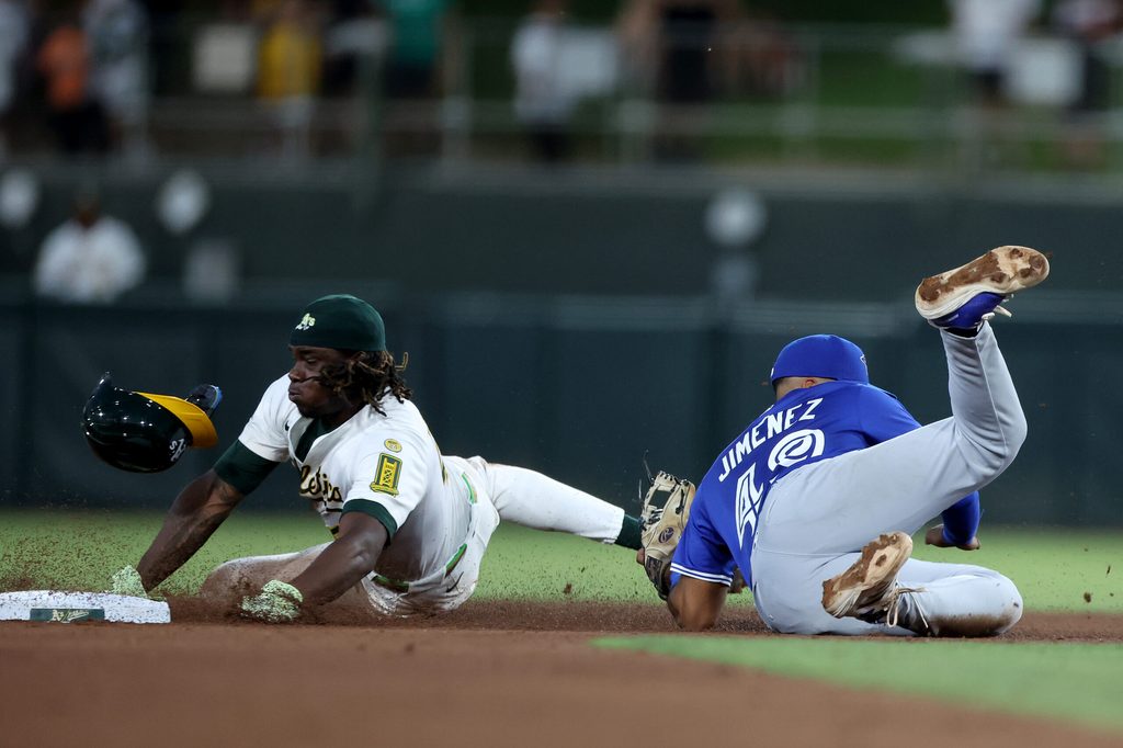 Jul 12, 2025; West Sacramento, California, USA; Athletics right fielder Lawrence Butler (4) is tagged out by Toronto Blue Jays second baseman Leo Jimenez (49) on a steal attempt during the fifth inning at Sutter Health Park. Mandatory Credit: Dennis Lee-Imagn Images