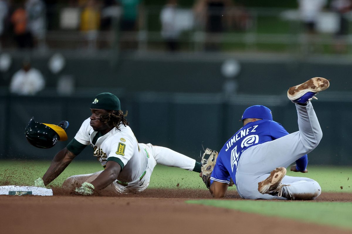 Jul 12, 2025; West Sacramento, California, USA; Athletics right fielder Lawrence Butler (4) is tagged out by Toronto Blue Jays second baseman Leo Jimenez (49) on a steal attempt during the fifth inning at Sutter Health Park. Mandatory Credit: Dennis Lee-Imagn Images