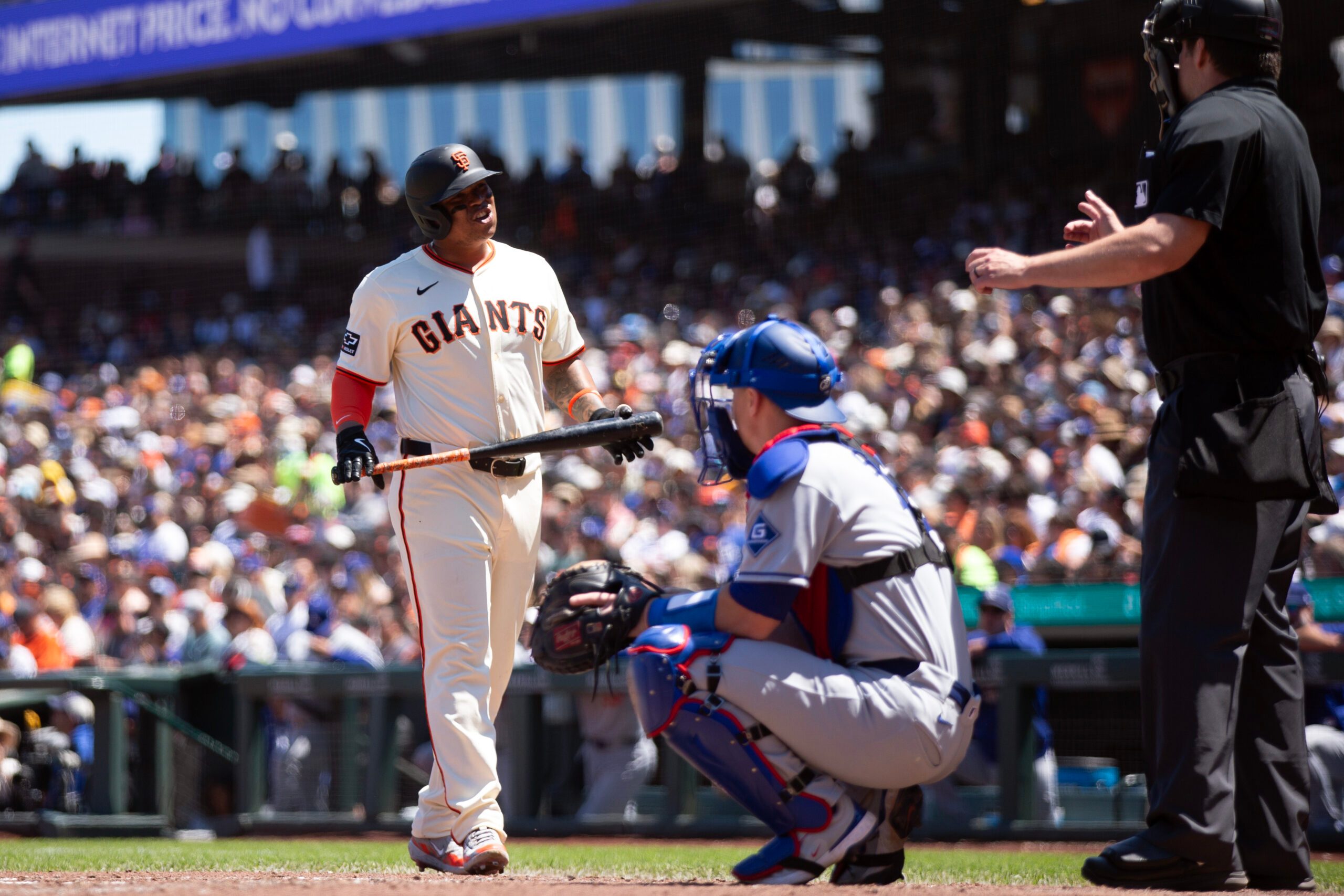 Jul 13, 2025; San Francisco, California, USA; San Francisco Giants designated hitter Rafael Devers (left) questions home plate umpire John Bacon after a pitch he thought was ball four was called strike two during the sixth inning against the Los Angeles Dodgers at Oracle Park. Mandatory Credit: D. Ross Cameron-Imagn Images
