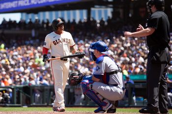 Jul 13, 2025; San Francisco, California, USA; San Francisco Giants designated hitter Rafael Devers (left) questions home plate umpire John Bacon after a pitch he thought was ball four was called strike two during the sixth inning against the Los Angeles Dodgers at Oracle Park. Mandatory Credit: D. Ross Cameron-Imagn Images
