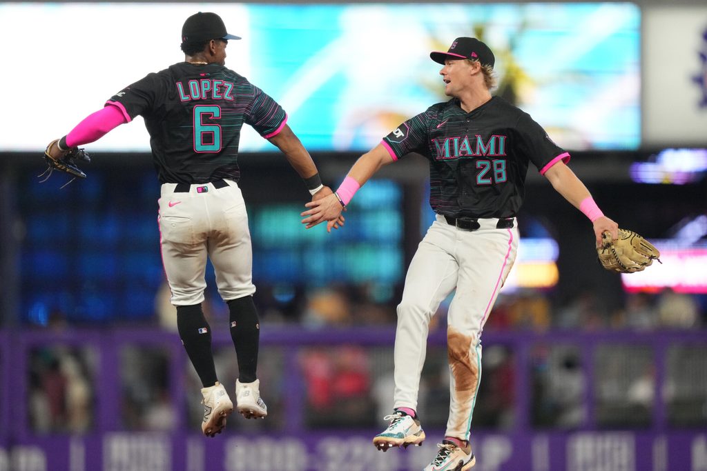 Jul 19, 2025; Miami, Florida, USA;  Miami Marlins left fielder Kyle Stowers (28) and shortstop Otto Lopez (6) celebrate a victory against the Kansas City Royals at loanDepot Park. Mandatory Credit: Jim Rassol-Imagn Images