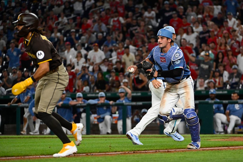 Jul 19, 2025; Washington, District of Columbia, USA; Washington Nationals catcher Drew Millas (81) prepares to tag out San Diego Padres right fielder Fernando Tatis Jr. (23) at third base during the eighth inning at Nationals Park. Mandatory Credit: Brad Mills-Imagn Images